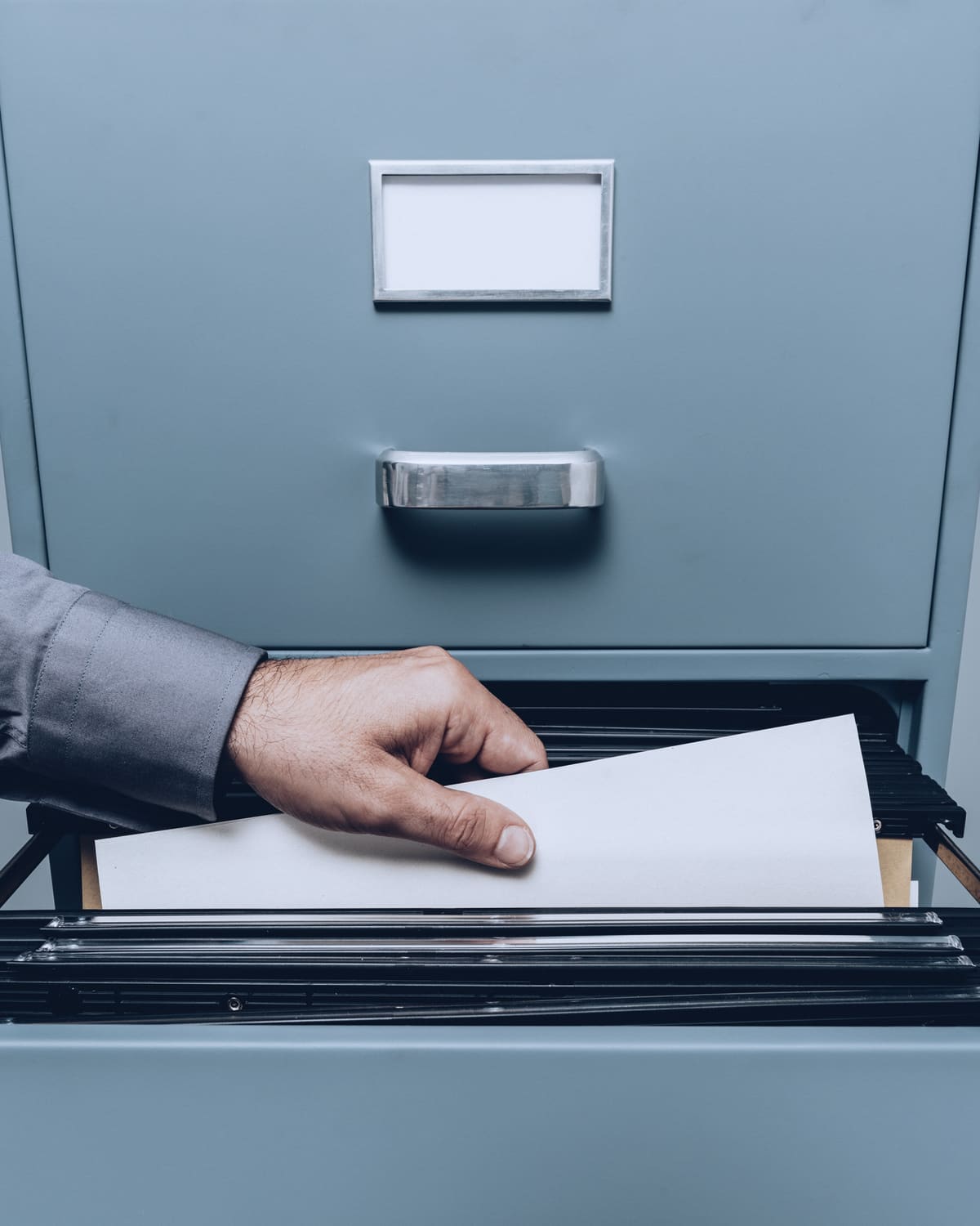 Gloved hands searching a drawer of court record cards