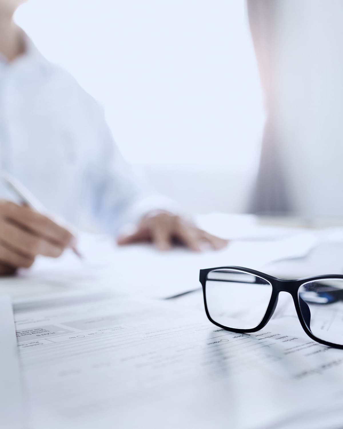 Tabbed corporate filings beside a laptop