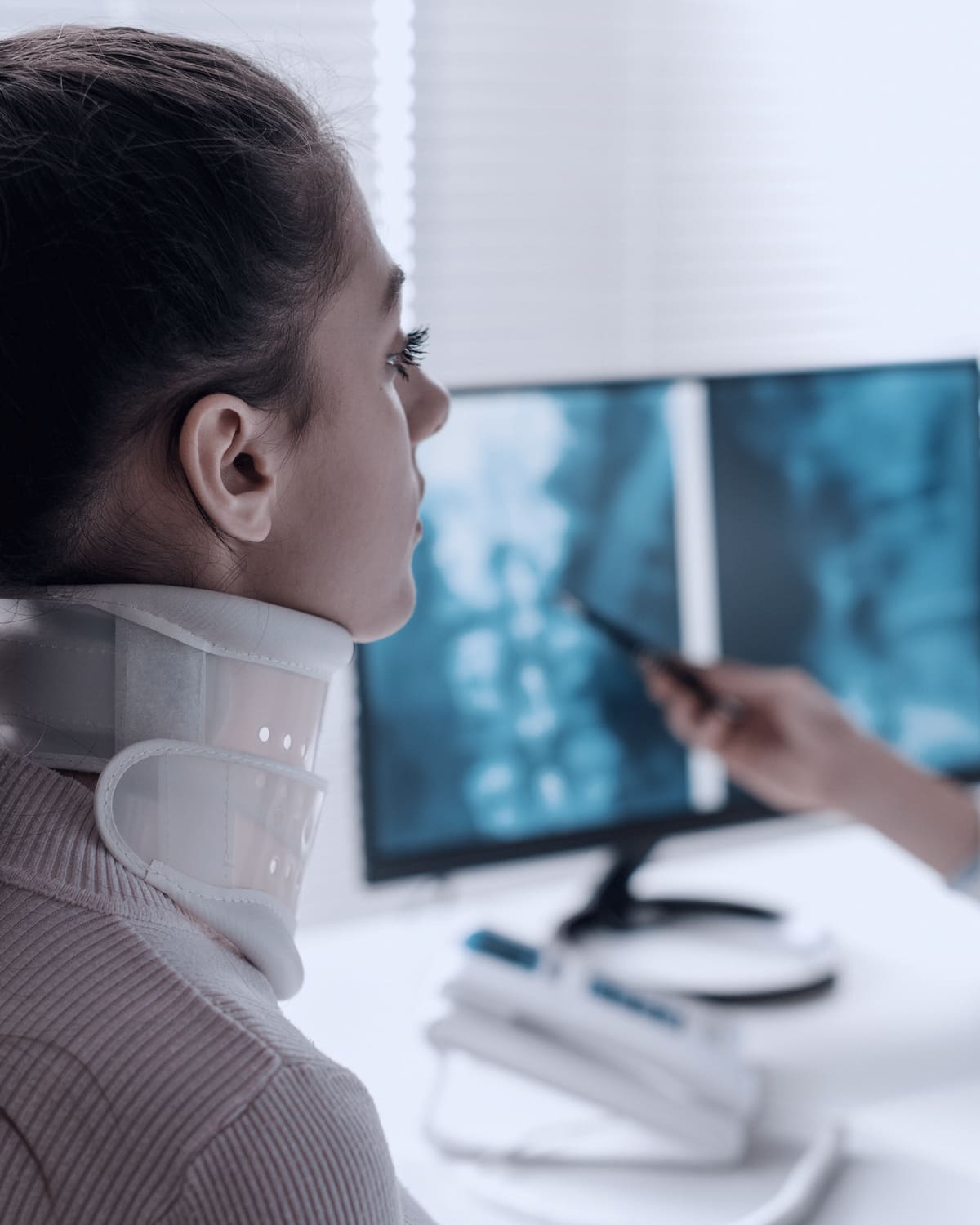 Neck brace on a car seat beside a smartphone and a claim form
