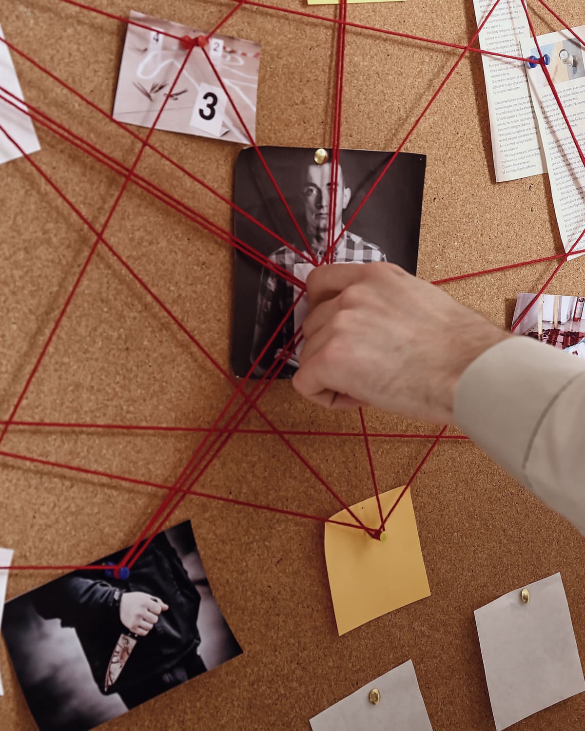Corkboard with a road map and red string