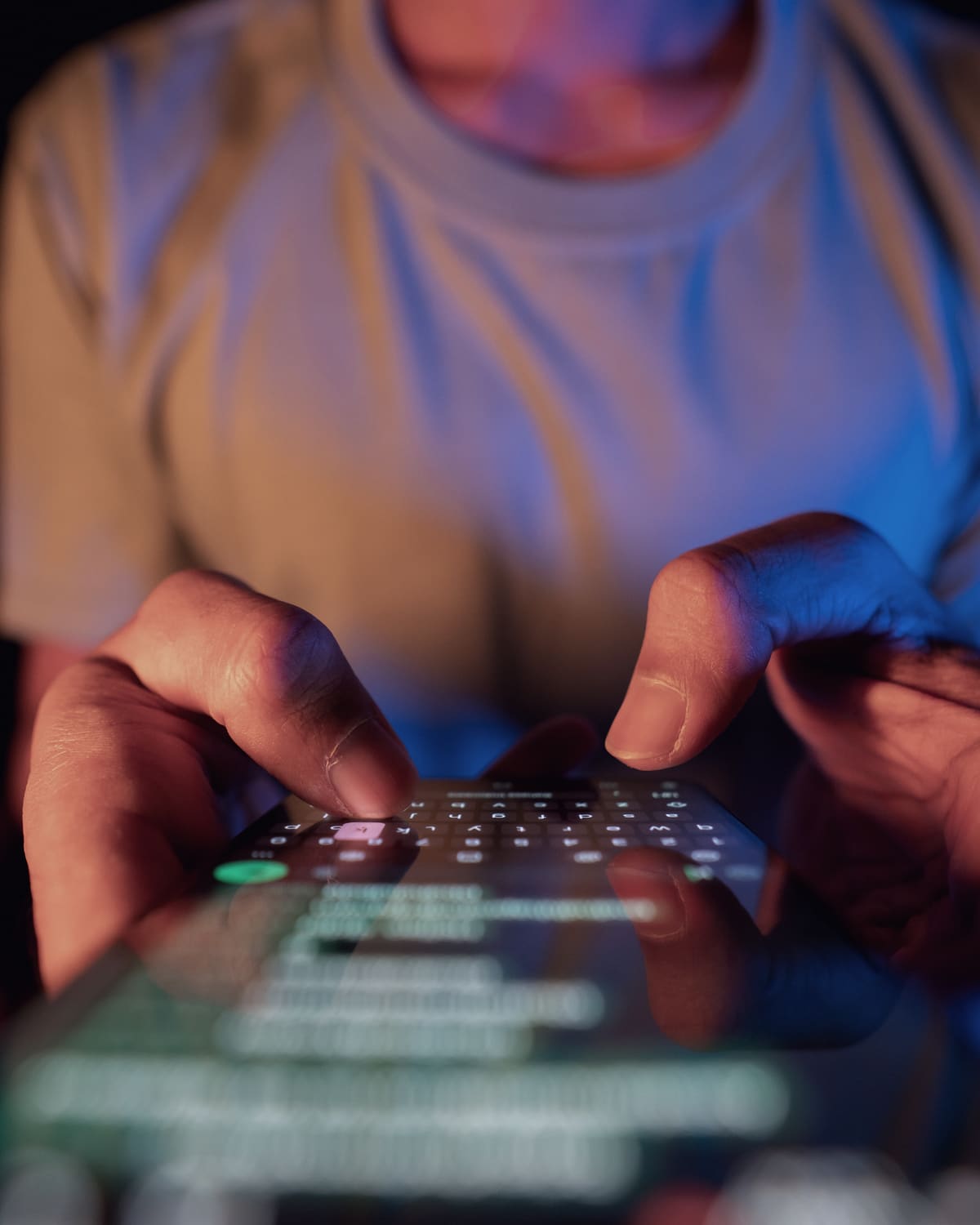Hand holding a glowing smartphone in a dark room